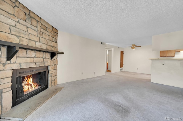 1830 S Pitkin Cir Unit B, Aurora, CO 80017 - unfurnished living room with a stone fireplace, carpet floors, a textured ceiling, and a ceiling fan