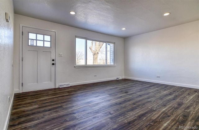 entryway with a textured ceiling and dark hardwood / wood-style floors