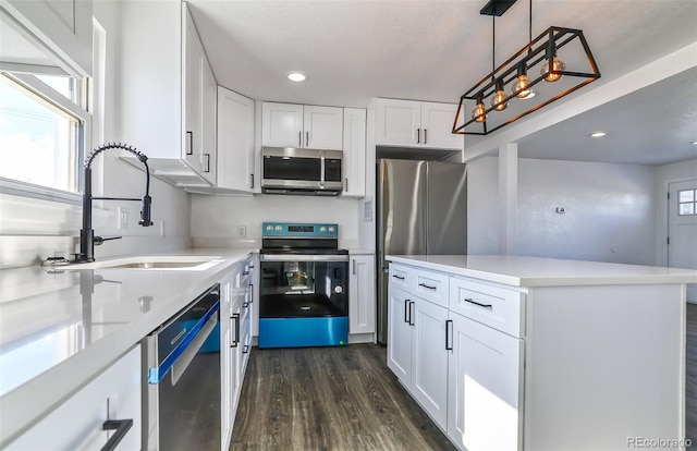 kitchen featuring sink, hanging light fixtures, dark hardwood / wood-style flooring, white cabinets, and appliances with stainless steel finishes