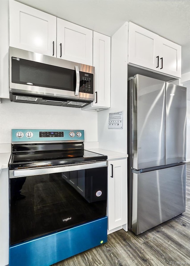 kitchen featuring white cabinets, stainless steel appliances, and dark wood-type flooring