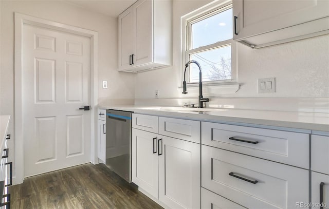 kitchen featuring white cabinetry, sink, stainless steel dishwasher, and dark hardwood / wood-style floors