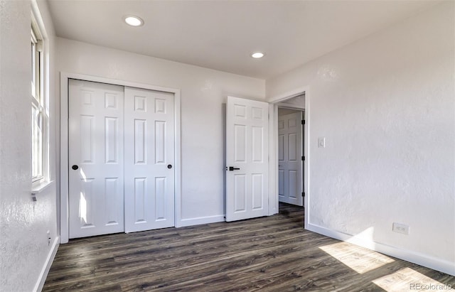 unfurnished bedroom featuring dark hardwood / wood-style flooring and a closet