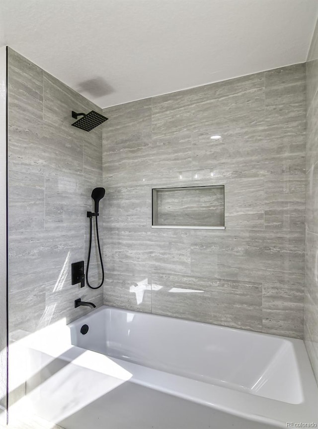 bathroom featuring tiled shower / bath