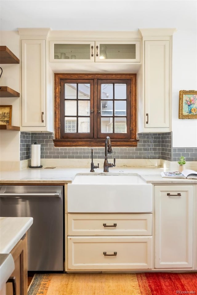 kitchen with a sink, open shelves, backsplash, and dishwasher