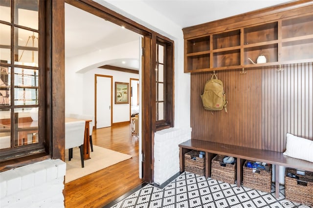mudroom featuring arched walkways and wood finished floors