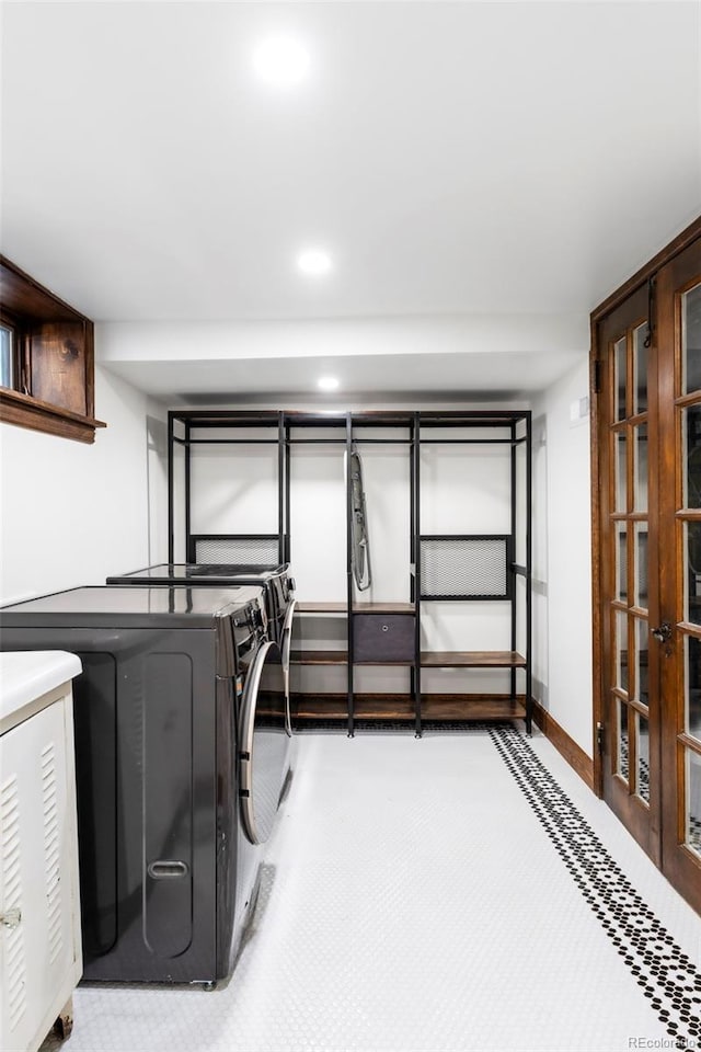 laundry area with laundry area, baseboards, washer and dryer, and french doors