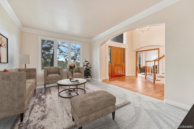 living room with crown molding, light hardwood / wood-style floors, and a chandelier