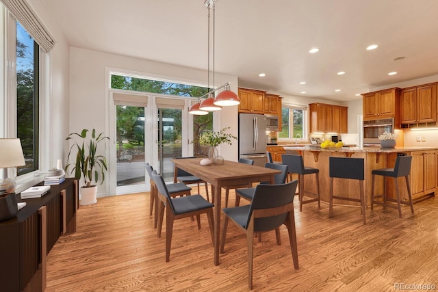 dining space with sink and light hardwood / wood-style floors