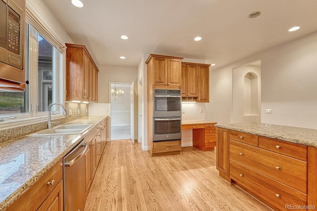 kitchen featuring light hardwood / wood-style floors, appliances with stainless steel finishes, light stone countertops, and sink