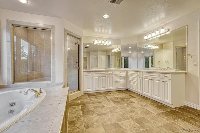 bathroom featuring vanity, a textured ceiling, and separate shower and tub