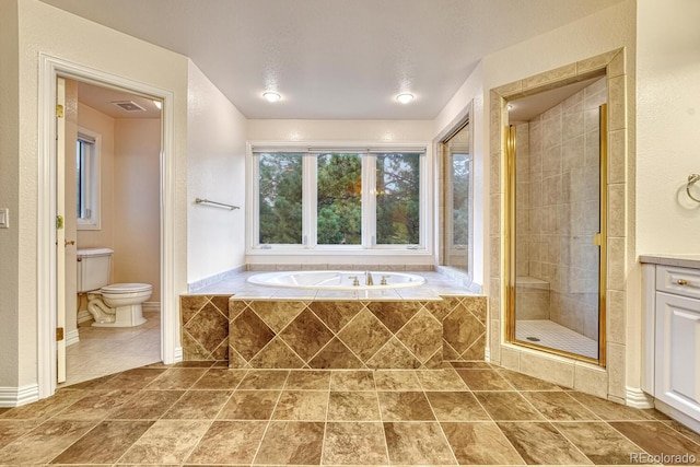 bathroom featuring toilet, tile patterned flooring, and shower with separate bathtub