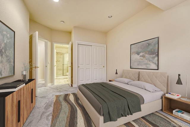 carpeted bedroom with ensuite bathroom and a closet