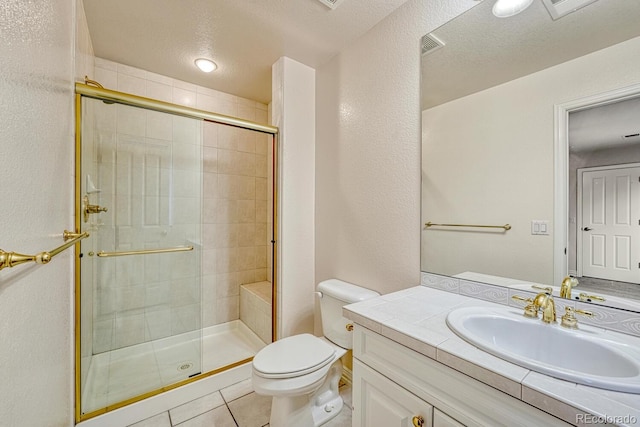 bathroom with tile patterned flooring, vanity, toilet, a shower with door, and a textured ceiling