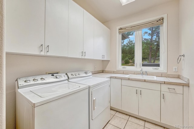 laundry room with cabinets, washing machine and dryer, sink, and light tile patterned flooring