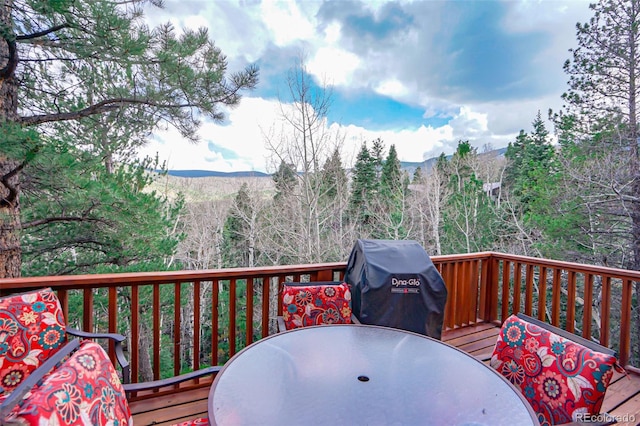 wooden terrace featuring a mountain view and a grill