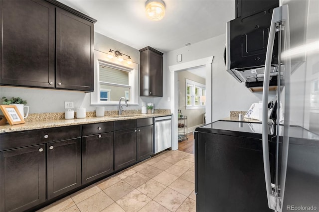 kitchen with light stone countertops, sink, stainless steel dishwasher, dark brown cabinets, and light tile patterned floors