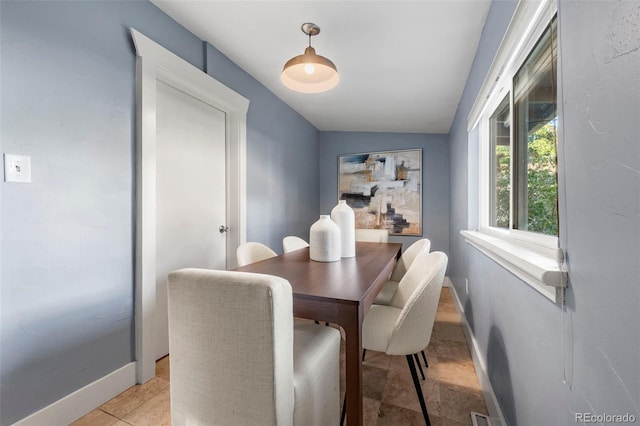 tiled dining area featuring lofted ceiling