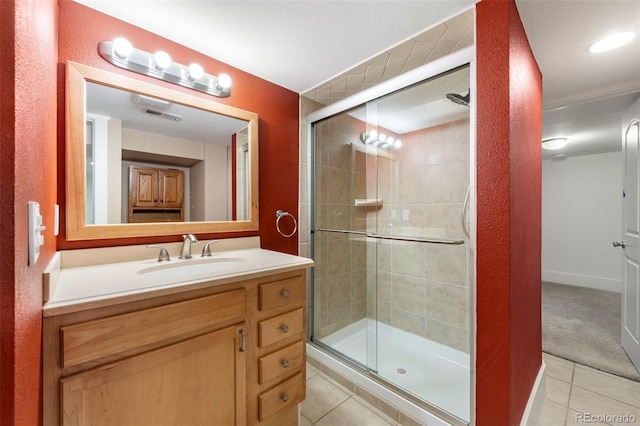 bathroom with tile patterned flooring, vanity, and an enclosed shower