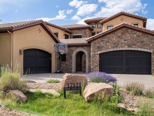17121 Snow Creek Ln, Morrison, CO 80465 - view of front of home with concrete driveway, a garage, stone siding, and a tile roof