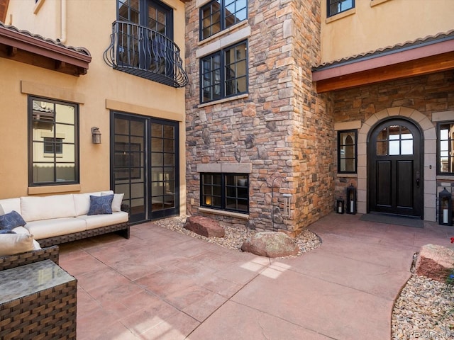 17121 Snow Creek Ln, Morrison, CO 80465 - entrance to property featuring stone siding, stucco siding, a patio, and outdoor lounge area