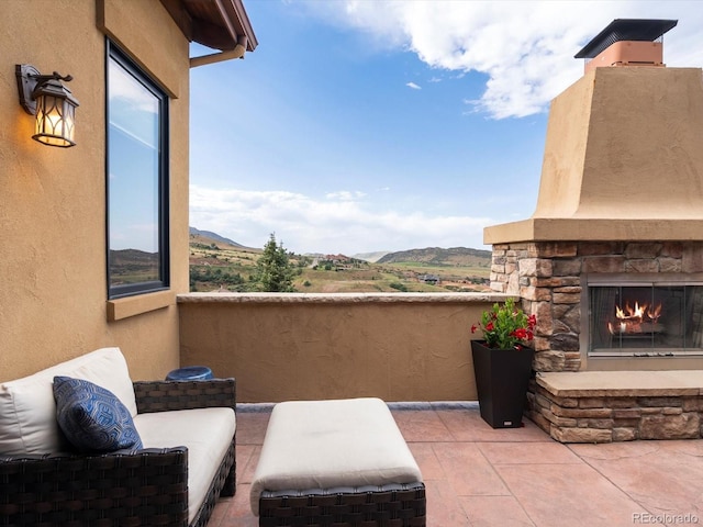 17121 Snow Creek Ln, Morrison, CO 80465 - view of patio / terrace featuring an outdoor stone fireplace and a mountain view