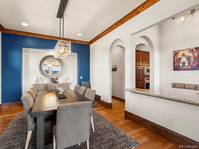 17121 Snow Creek Ln, Morrison, CO 80465 - dining area featuring arched walkways, wood finished floors, recessed lighting, and a chandelier