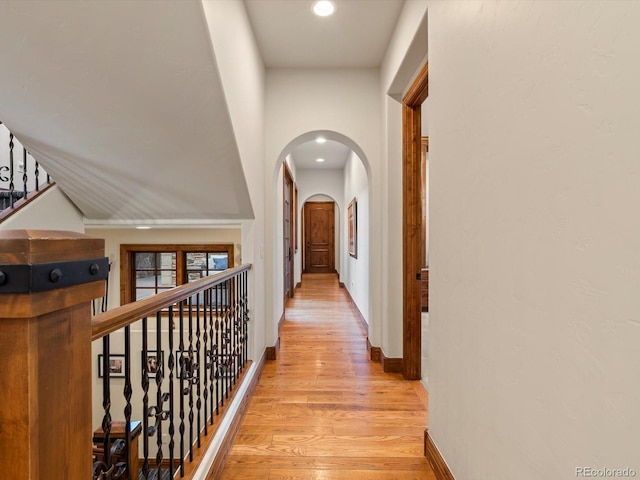 17121 Snow Creek Ln, Morrison, CO 80465 - hallway with light wood finished floors, arched walkways, and recessed lighting