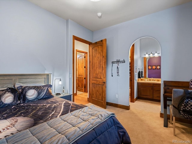 17121 Snow Creek Ln, Morrison, CO 80465 - bedroom with light colored carpet, arched walkways, and ensuite bath