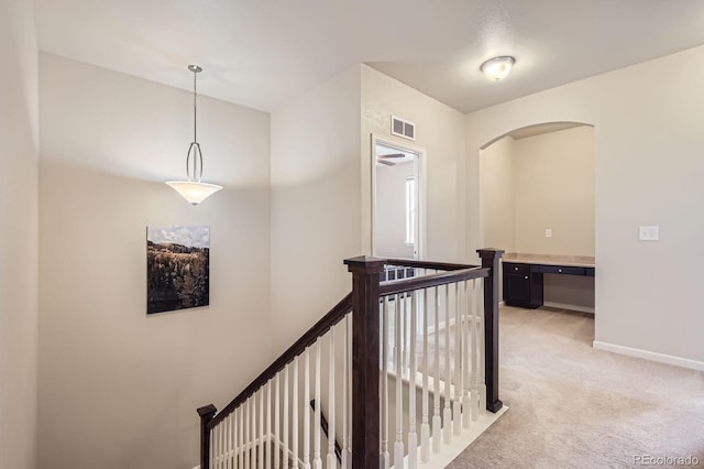 853 Jenny Ln, Berthoud, CO 80513 - hallway featuring light colored carpet, an upstairs landing, baseboards, and arched walkways