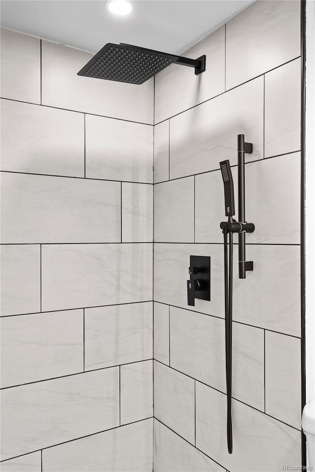 bathroom view of a tile shower and recessed lighting