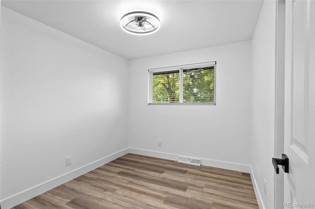 empty room featuring baseboards and wood finished floors