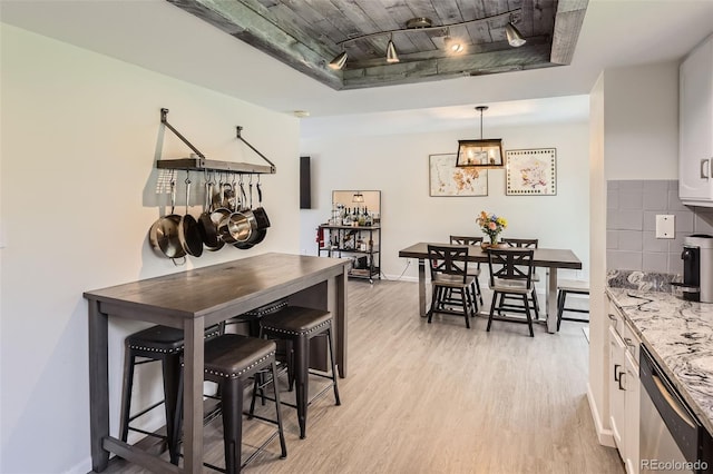 3235 S Newland St, Denver, CO 80227 - dining area featuring light wood finished floors, a raised ceiling, and wood ceiling
