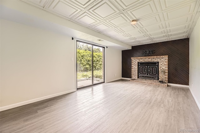 3235 S Newland St, Denver, CO 80227 - unfurnished living room featuring an ornate ceiling, wood walls, a fireplace, and wood finished floors