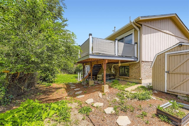 3235 S Newland St, Denver, CO 80227 - back of house with a storage unit, stairway, a wooden deck, and a garden