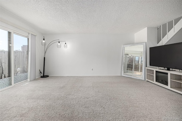 unfurnished living room with baseboards, a textured ceiling, and carpet