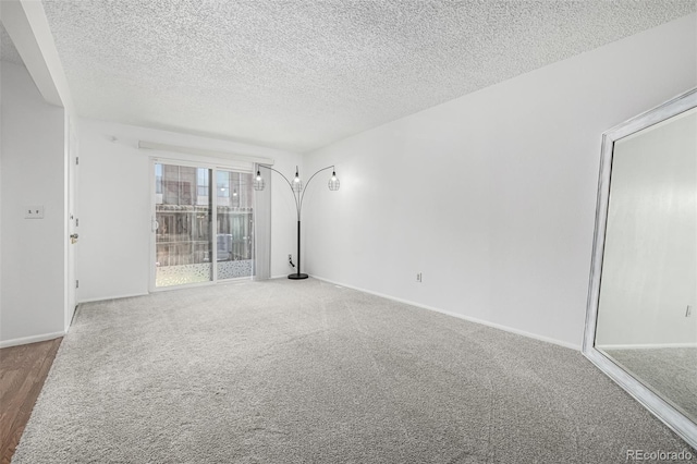 empty room with baseboards, carpet floors, and a textured ceiling