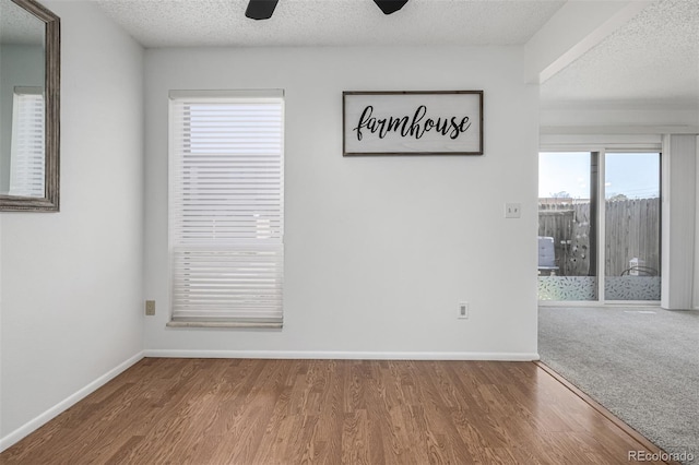 unfurnished room with a textured ceiling, wood finished floors, and ceiling fan