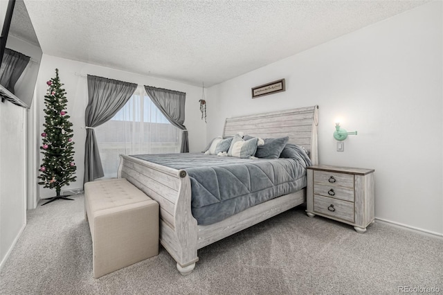 bedroom featuring carpet flooring, a textured ceiling, and baseboards