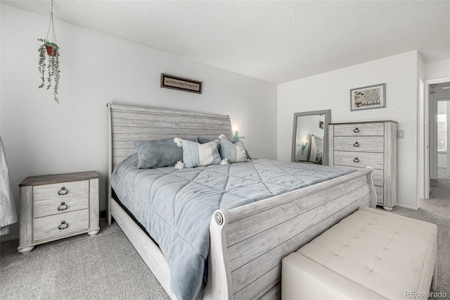 bedroom with a textured ceiling and light carpet