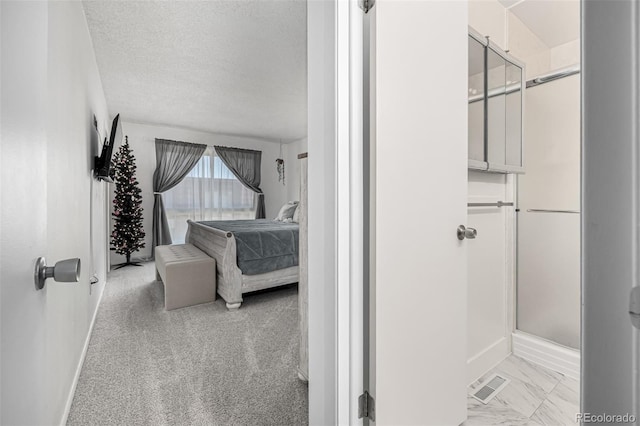 bathroom with a stall shower, baseboards, visible vents, and a textured ceiling