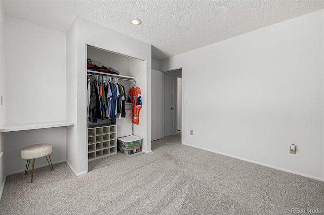 bedroom featuring a closet, carpet floors, a textured ceiling, and baseboards