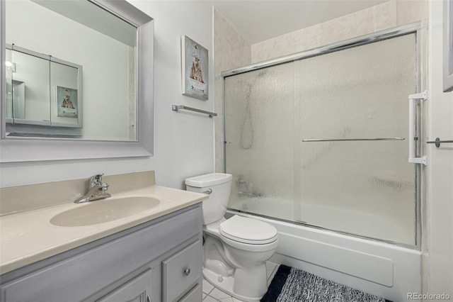 full bath featuring vanity, toilet, and shower / bath combination with glass door