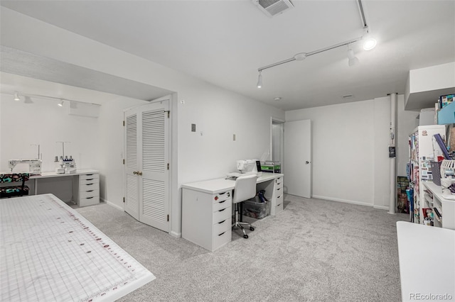 office space featuring visible vents, light colored carpet, track lighting, and baseboards