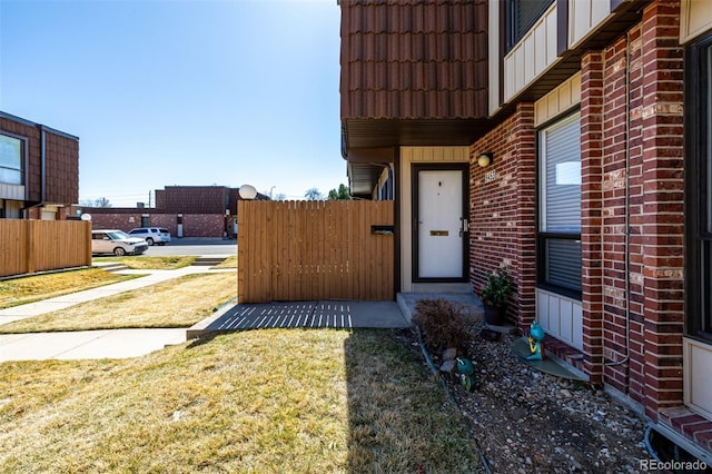 property entrance with a tiled roof, a yard, and board and batten siding