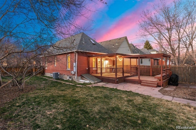 3346 W 30th Ave, Denver, CO 80211 - back of property at dusk featuring a fenced backyard, a deck, a shingled roof, and brick siding