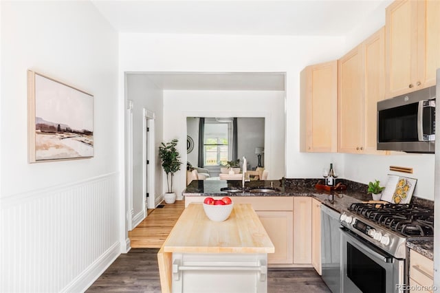 3346 W 30th Ave, Denver, CO 80211 - kitchen with appliances with stainless steel finishes, light brown cabinets, dark wood-style floors, and a peninsula