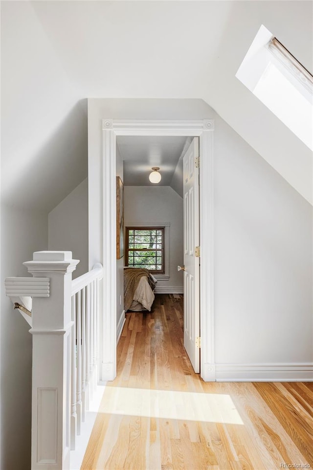 3346 W 30th Ave, Denver, CO 80211 - hallway with vaulted ceiling, a skylight, light wood-style floors, and an upstairs landing