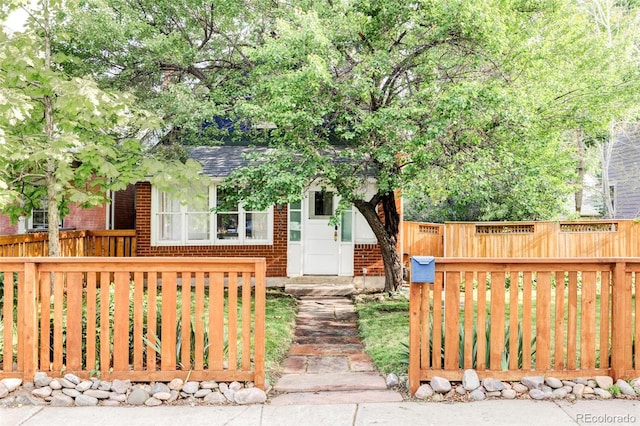 3346 W 30th Ave, Denver, CO 80211 - view of front facade with brick siding, a fenced front yard, and roof with shingles