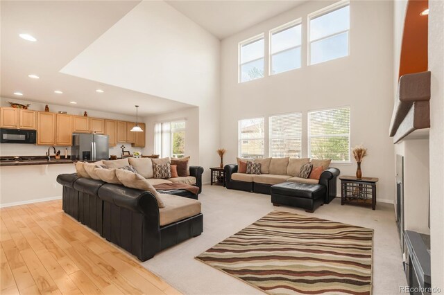13664 Cherry St, Thornton, CO 80602 - living room featuring baseboards, light wood-style floors, recessed lighting, and a towering ceiling