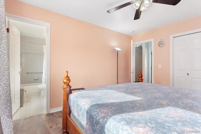 bedroom with ceiling fan, light wood-type flooring, ensuite bath, and a closet